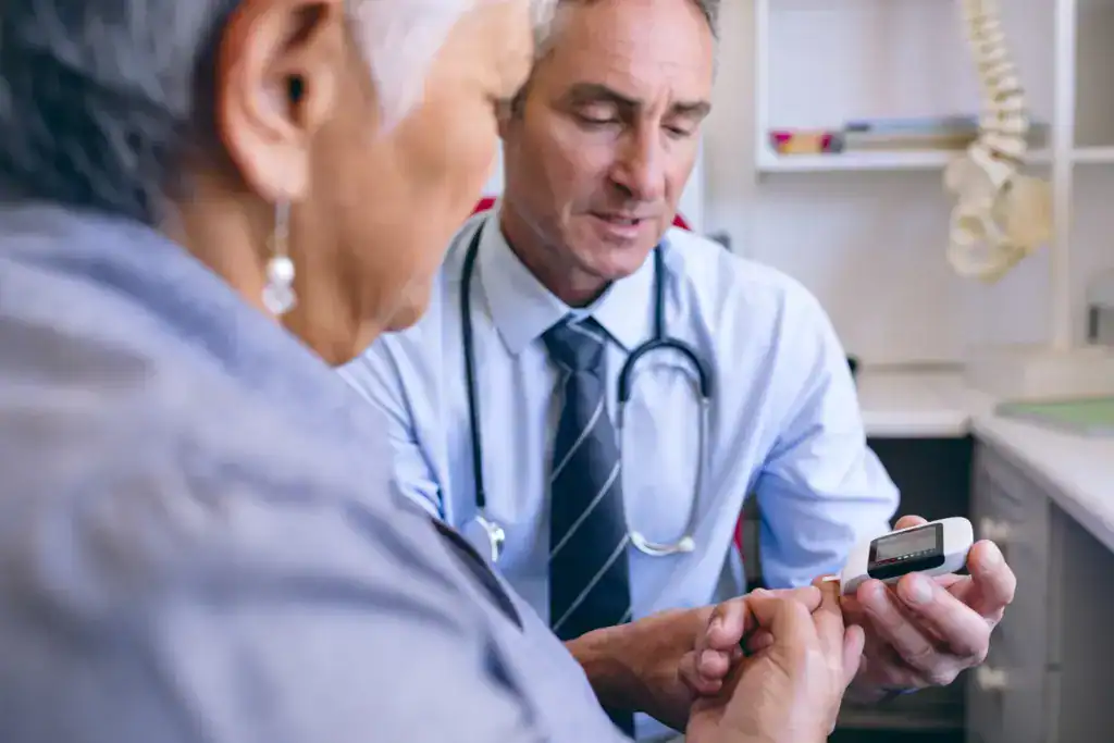 Arzt untersucht aeltere Patientin im Behandlungsraum